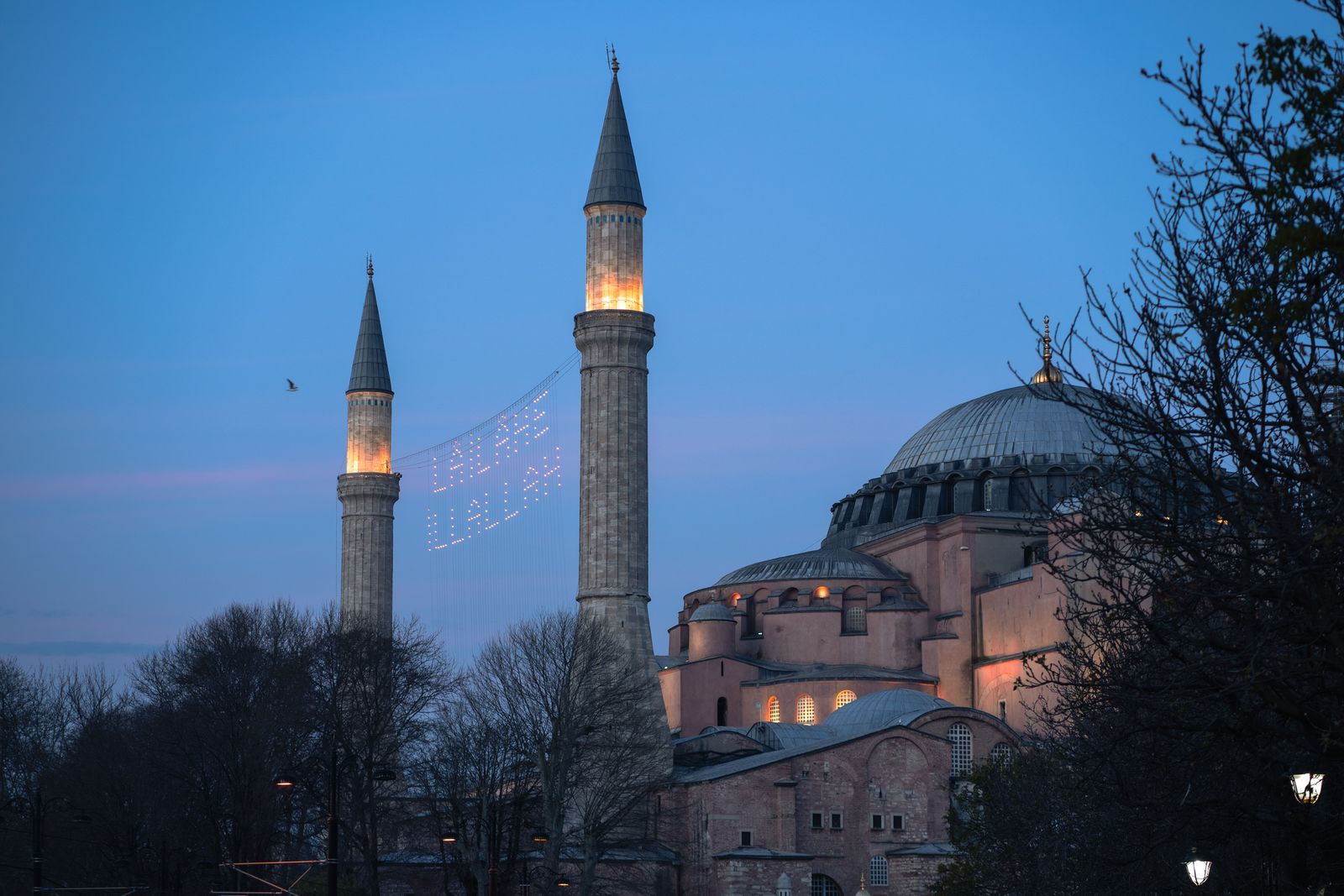 Minarets of Hagia Sophia lit at dusk beside the Hippodrome