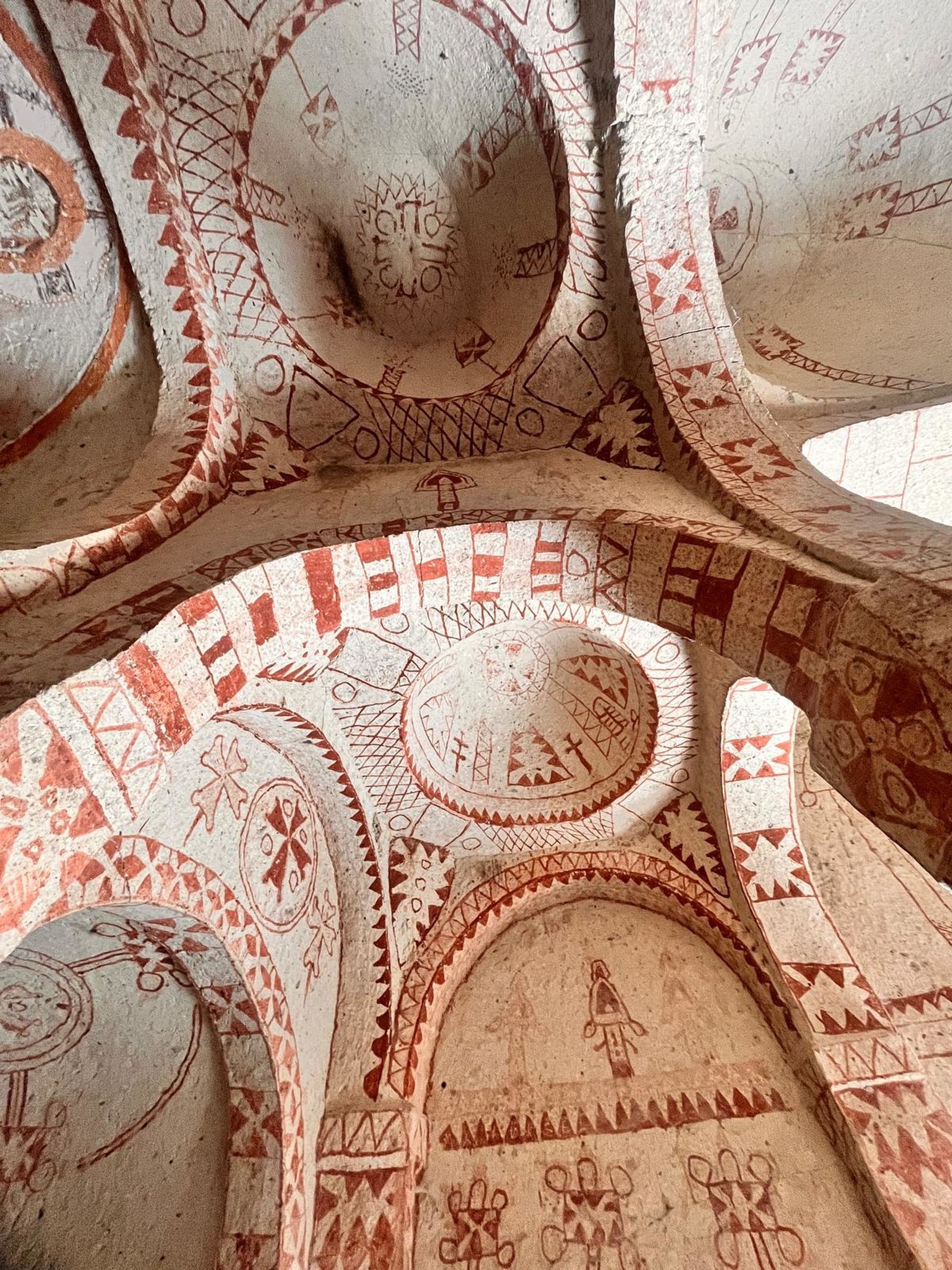Red and white frescoes on a cave church ceiling